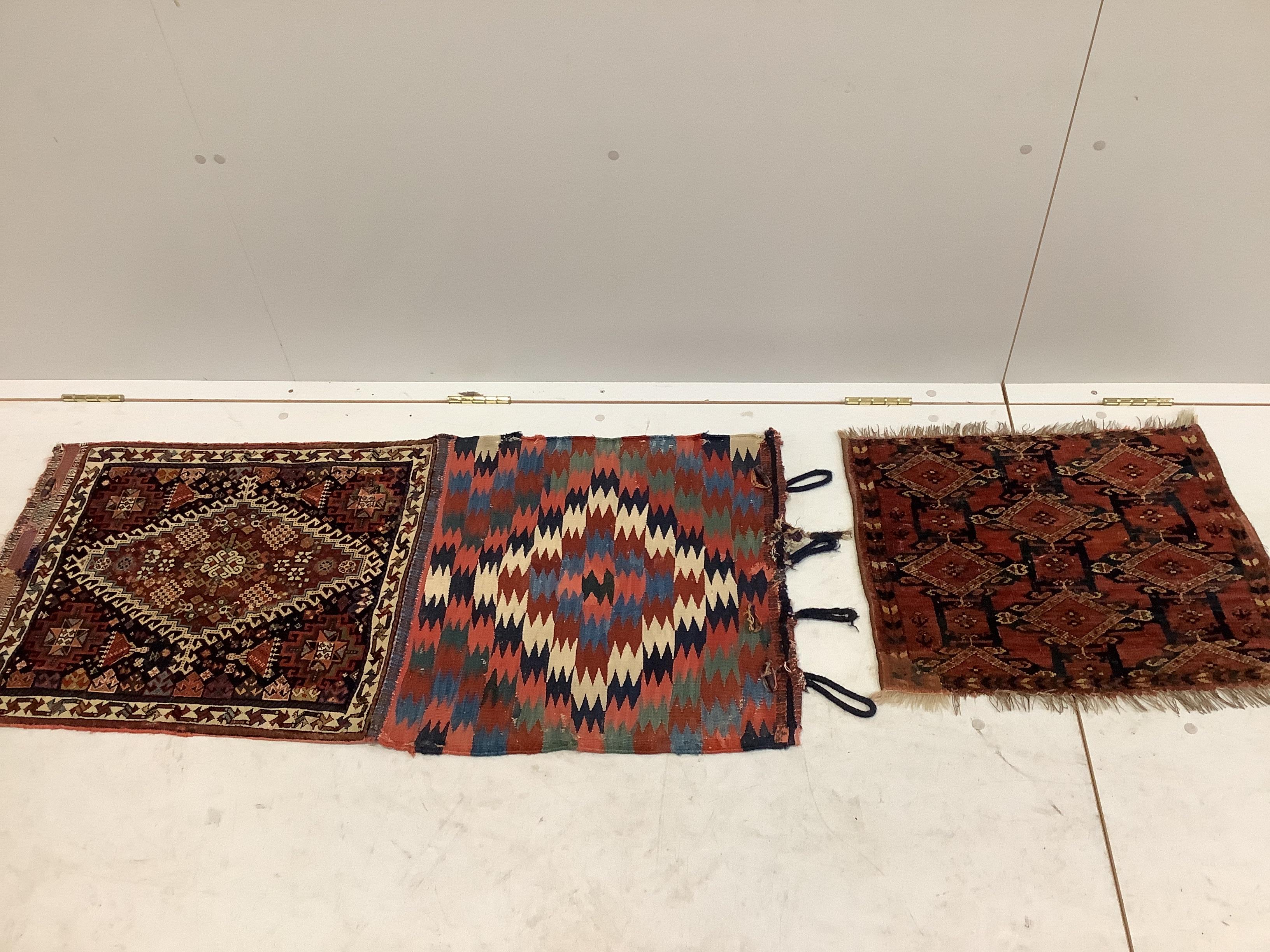 An antique Caucasian wall hanging, (converted saddlebag), width 120cm, depth 55cm, together with a smaller antique Tekke bag face